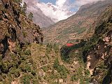 Manaslu 05 06 Buri Gandaki Bridge To Rana With Lapuchun and Dwijen Himal A short distance beyond Deng the trail crosses the Buri Gandaki onto what is now the north bank, and climbs to Rana (1980m). The red vegetation on the far bank is buckwheat. In the distance to the north on the Tibetan border are Lapuchun (5960m) and Dwijen Himal (5521m).